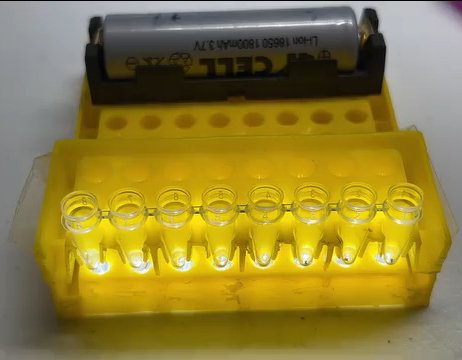 Finished unit with an 18650 battery in its clip and a lit 8-tube strip